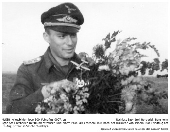 Egon Stoll-Berberich mit Blumensträußen und einem Pokal als Geschenk kurz nach der Rückkehr von seinem 500. Feindflug am 31. August 1943 in Seschtschinskaya. NLESB_Kriegsbilder_lose_500_Feindflug_0007.