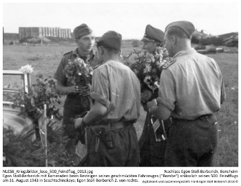 Egon Stoll-Berberich mit Kameraden beim Besteigen seines geschmückten Fahrzeuges ("Bombe") anlässlich seines 500. Feindflugs am 31. August 1943 in Seschtschinskaya; Egon Stoll-Berberich 2. von rechts. NLESB_Kriegsbilder_lose_500_Feindflug_0013.
