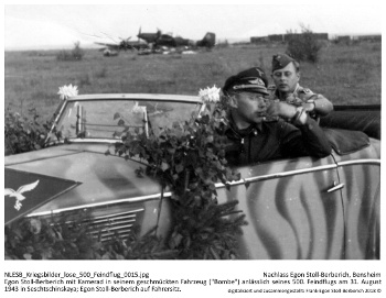 Egon Stoll-Berberich mit Kamerad in seinem geschmückten Fahrzeug ("Bombe") anlässlich seines 500. Feindflugs am 31. August 1943 in Seschtschinskaya; Egon Stoll-Berberich auf Fahrersitz. NLESB_Kriegsbilder_lose_500_Feindflug_0015.