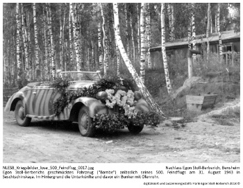 Egon Stoll-Berberichs geschmücktes Fahrzeug ("Bombe") anlässlich seines 500. Feindflugs am 31. August 1943 in Seschtschinskaya. Im Hintergrund die Unterkünfte und davor ein Bunker mit Ofenrohr. NLESB_Kriegsbilder_lose_500_Feindflug_0017.