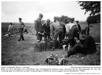 Bilder aus dem Fotoalbum von Unteroffizier Egon Stoll-Berberich während seiner Dienstzeit bei der Schlachtgruppe 50, hier: Mit Schlachtgruppe 50 im Manöver auf dem Heuberg, August 1938 bei der Essensausgabe mitsamt Maskottchen "Piefke". NLESB_Kriegsbilder_Album1_0022.