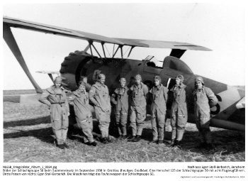 Bilder der Schlachtgruppe 50 beim Sudeteneinsatz im September 1938 in Grottkau (heute Grodków). Henschel 123 der Schlachtgruppe 50 mit 6 Flugzeugführern der Schlachtgruppe 50. Dritte Person von links: Egon Stoll-Berberich. NLESB_Kriegsbilder_Album1_0037.